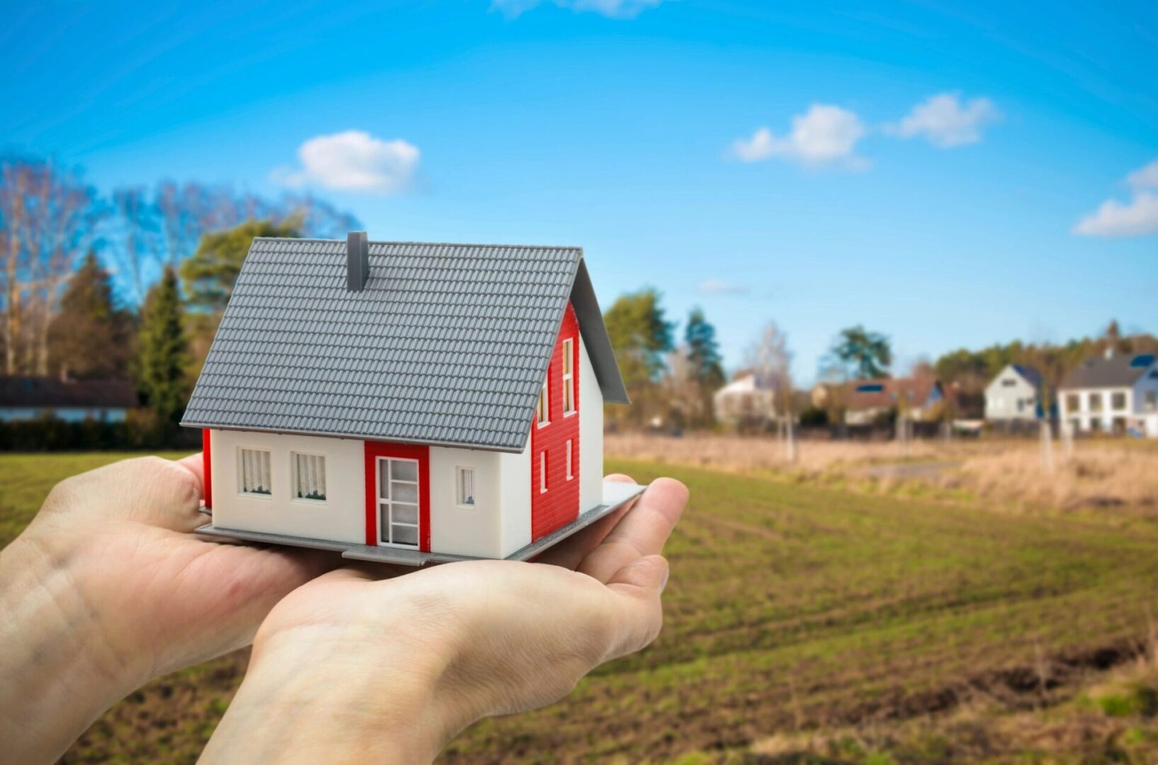 a small house model on the palms of hands